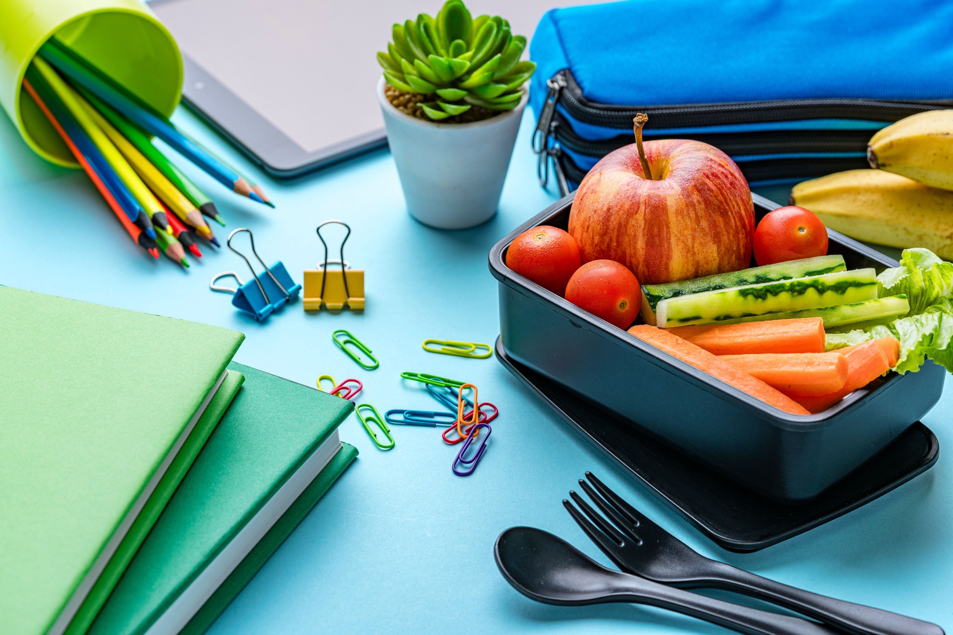 Lunch box and school or office supplies. Healthy eating for students or at work. Fruits and vegetables for vegetarian diet